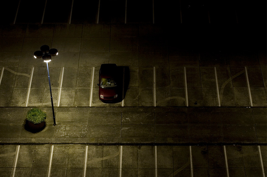 dark parking lot with one car in it