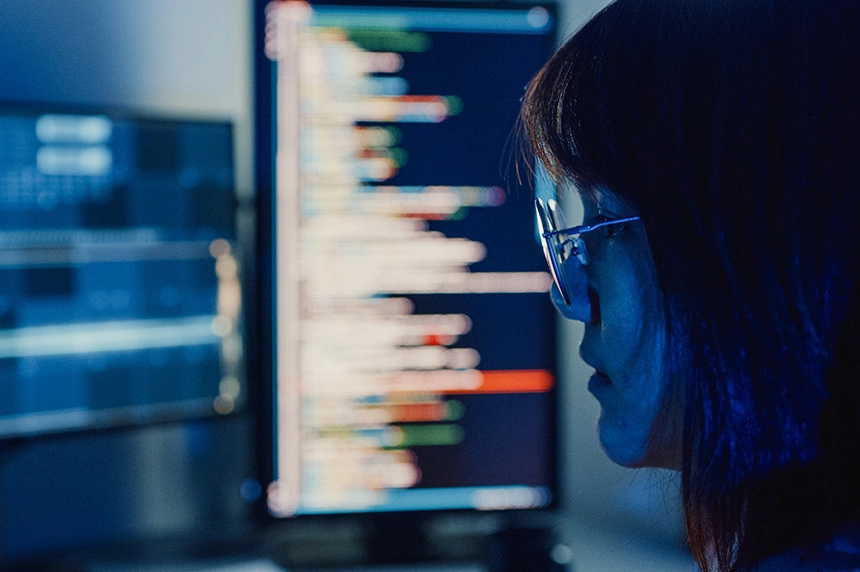 person working on busy computer monitors